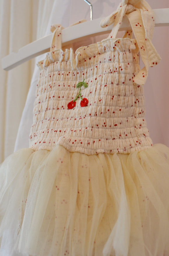 Cream-colored dress with floral embroidery on a mannequin against a light background