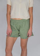 Person wearing green checkered shorts on a plain background