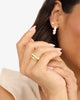 Close-up of a woman's hand wearing a gold ring with a blurred background