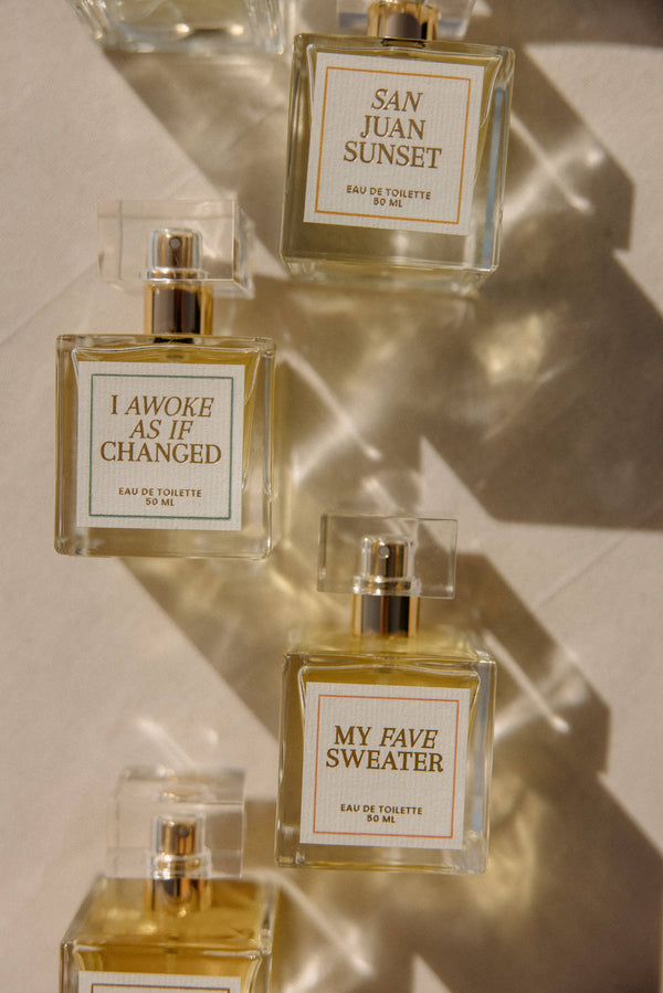 Four perfume bottles with labeled names on a light background