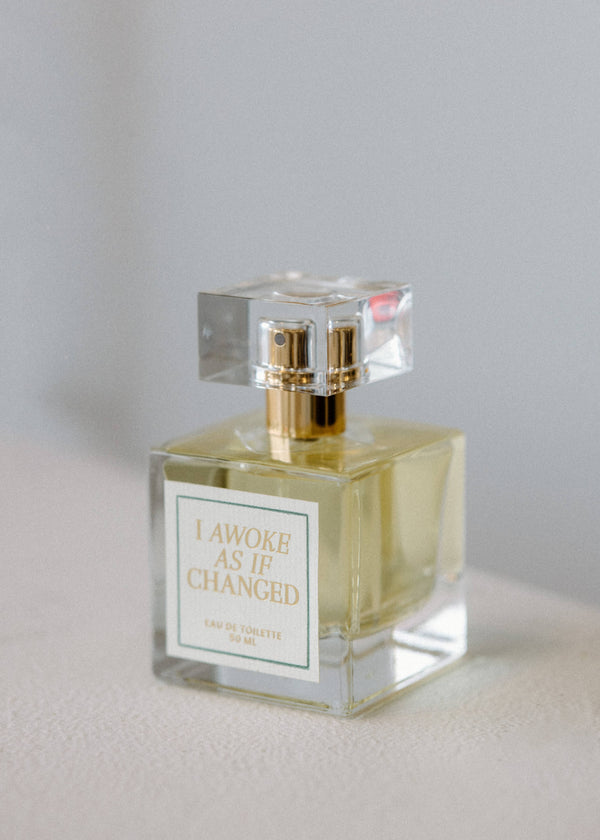 Perfume bottle with gold cap on a light gray background
